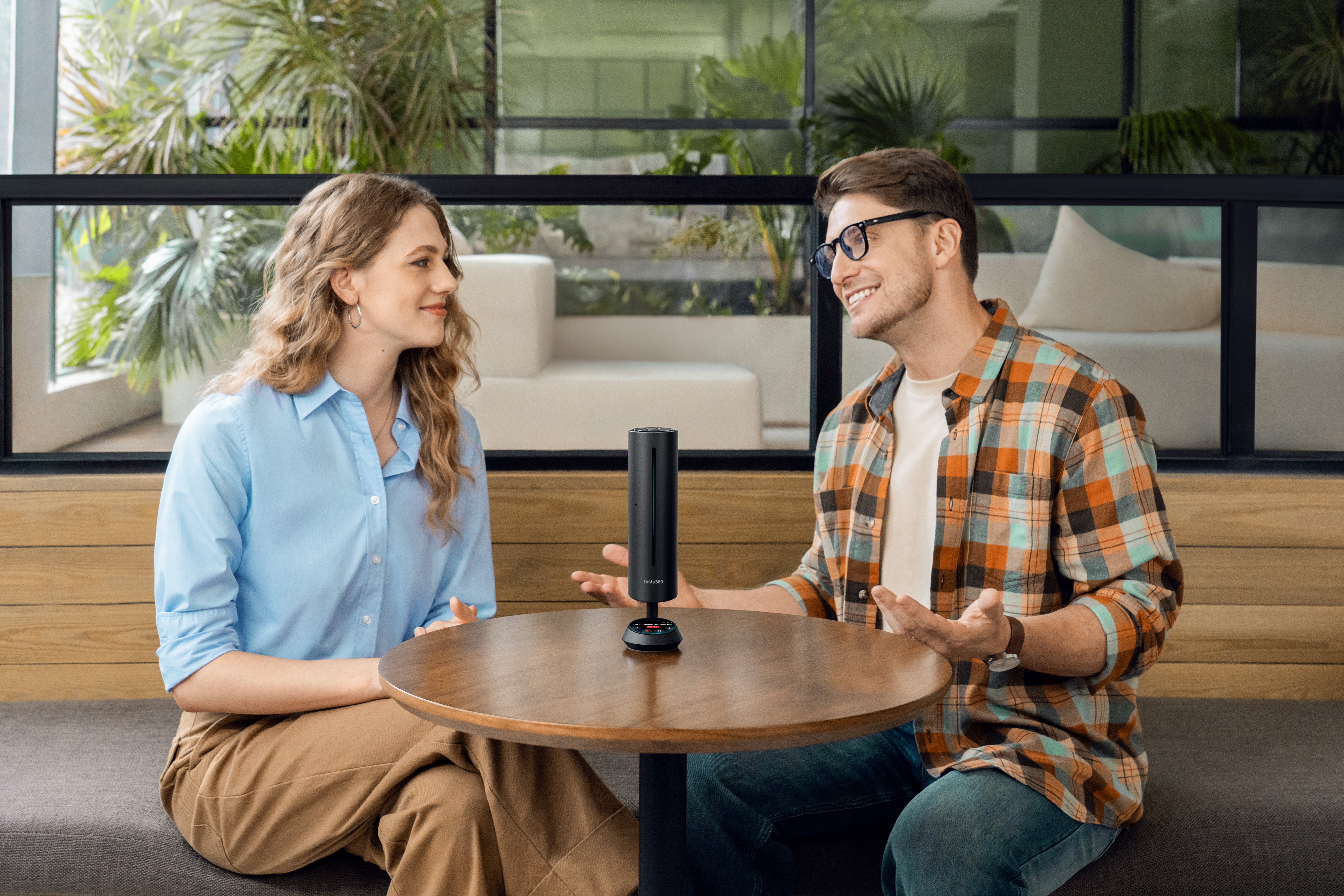 Two people having an informal meeting with Insta360 Wave in between them, catching all of their meeting notes for future reference.